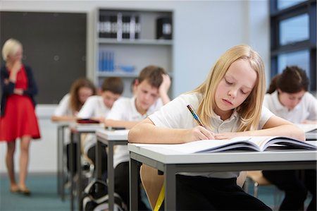 picture of kids in a classroom with a teacher - Female teacher watching class doing educational exam Stock Photo - Premium Royalty-Free, Code: 649-07280103