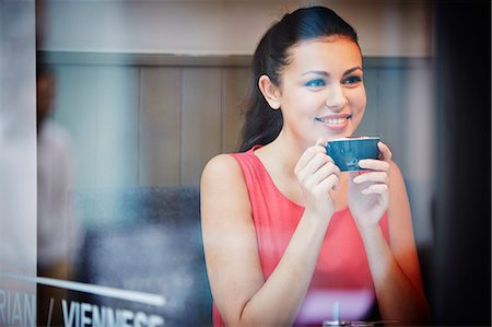 Young woman sitting in cafe with hot drink Stock Photo - Premium Royalty-Free, Code: 649-07280181