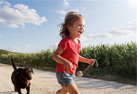 Girl and dog running through field Stock Photo - Premium Royalty-Free, Code: 649-07280319