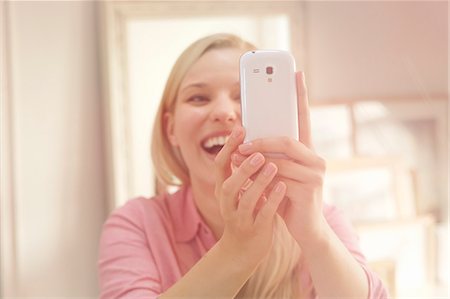 Young woman taking self portrait photograph using smartphone Foto de stock - Sin royalties Premium, Código: 649-07280735