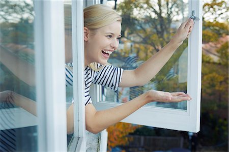 simsearch:649-07280729,k - Young woman leaning out of window Stock Photo - Premium Royalty-Free, Code: 649-07280731