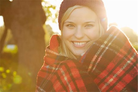simsearch:649-07280729,k - Portrait of young woman in park, tartan picnic blanket around shoulders Stock Photo - Premium Royalty-Free, Code: 649-07280748