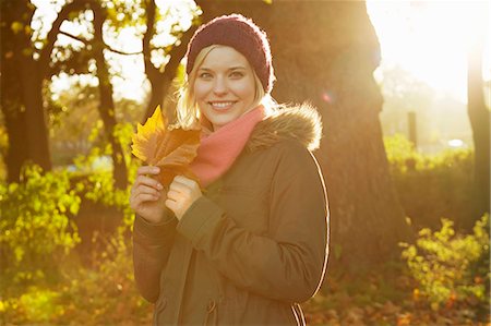 simsearch:649-07280729,k - Portrait of young woman in park, holding autumn leaf Stock Photo - Premium Royalty-Free, Code: 649-07280742