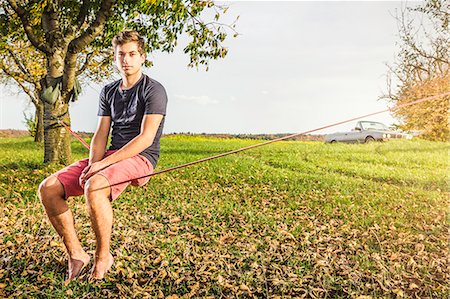 Portrait of young man sitting on slackline Photographie de stock - Premium Libres de Droits, Code: 649-07280816