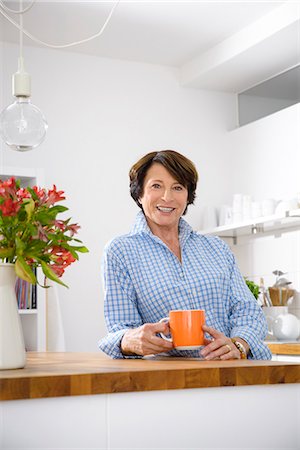 senior coffee alone - Portrait of youthful senior woman at home in kitchen Stock Photo - Premium Royalty-Free, Code: 649-07280935