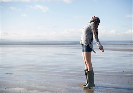 fresh air - Young woman standing on beach looking up, Brean Sands, Somerset, England Stock Photo - Premium Royalty-Free, Code: 649-07281022