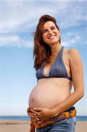 simsearch:649-07436413,k - Pregnant woman on beach, hand on stomach Stock Photo - Premium Royalty-Free, Code: 649-07436397