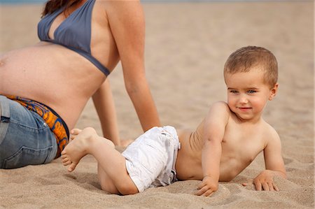 simsearch:649-07436413,k - Cropped image of pregnant mother and son lying on beach Stock Photo - Premium Royalty-Free, Code: 649-07436399