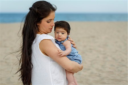 simsearch:649-07436413,k - Mother on beach carrying baby in arms Stock Photo - Premium Royalty-Free, Code: 649-07436404