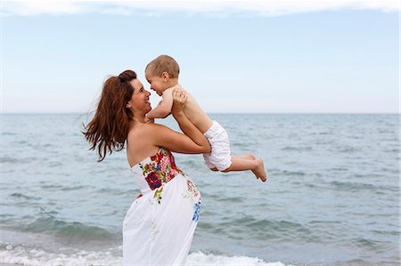 simsearch:649-07436413,k - Pregnant woman lifting toddler on beach Stock Photo - Premium Royalty-Free, Code: 649-07436419