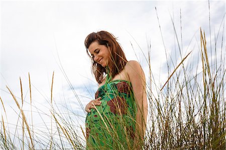 Pregnant woman standing in field Stock Photo - Premium Royalty-Free, Code: 649-07436427