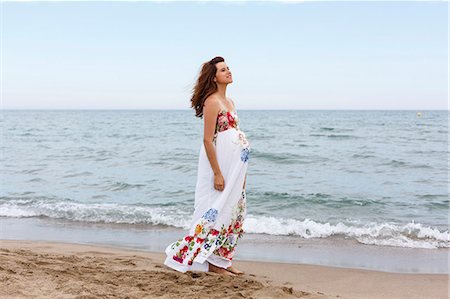 Pregnant woman walking along beach Stock Photo - Premium Royalty-Free, Code: 649-07436420