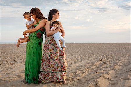 Mothers standing on beach holding baby and toddler Stock Photo - Premium Royalty-Free, Code: 649-07436434