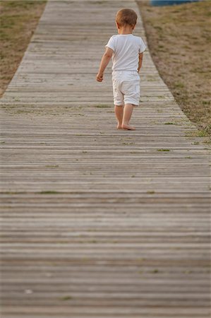 simsearch:649-07436413,k - Rear view of toddler walking along boardwalk Stock Photo - Premium Royalty-Free, Code: 649-07436444