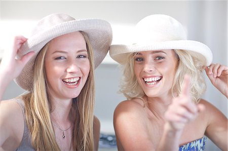 Young women trying on hats Photographie de stock - Premium Libres de Droits, Code: 649-07436523