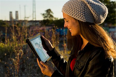 Young woman looking at digital tablet screen Stock Photo - Premium Royalty-Free, Code: 649-07436676