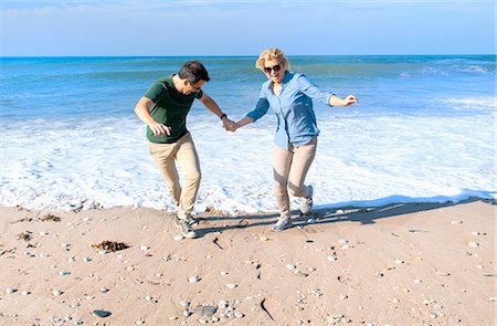 Mid adult couple fooling around on beach, Thurlestone, Devon, UK Foto de stock - Sin royalties Premium, Código: 649-07436702