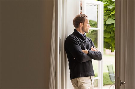 simsearch:649-07436838,k - Mid adult man looking out of window, arms folded Stock Photo - Premium Royalty-Free, Code: 649-07436784