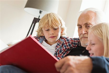 Grandfather reading book to grandchildren Photographie de stock - Premium Libres de Droits, Code: 649-07436832