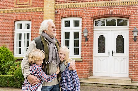 family house - Grandfather with arms around grandchildren outside house Stock Photo - Premium Royalty-Free, Code: 649-07436845