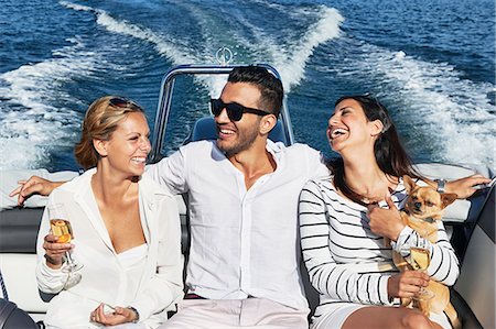 flirting - Young man on boat with arms around women, Gavle, Sweden Stock Photo - Premium Royalty-Free, Code: 649-07437166