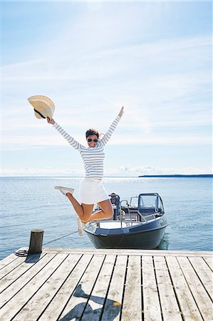 picture of mini skirt - Young woman leaping mid air on pier, Gavle, Sweden Stock Photo - Premium Royalty-Free, Code: 649-07437173