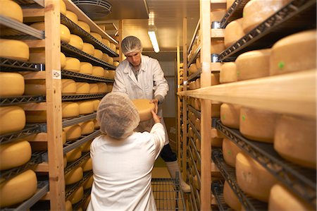 shelves - Workers putting cheese round for storage at farm factory Stock Photo - Premium Royalty-Free, Code: 649-07437204