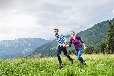 Couple holdings hands and running, Tirol, Austria Stock Photo - Premium Royalty-Free, Code: 649-07437338