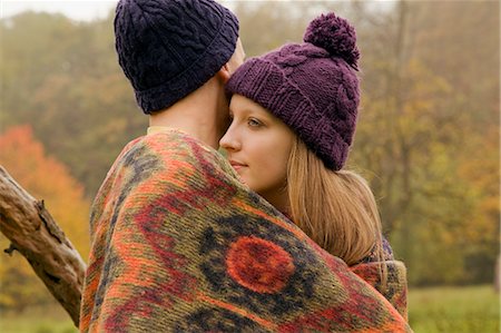 Close up of young couple wrapped in blanket in misty park Stock Photo - Premium Royalty-Free, Code: 649-07437638