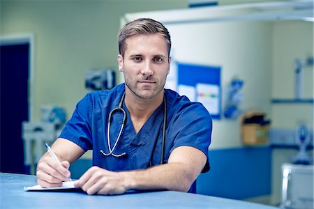 Portrait of male doctor writing up medical notes Stock Photo - Premium Royalty-Free, Code: 649-07437687