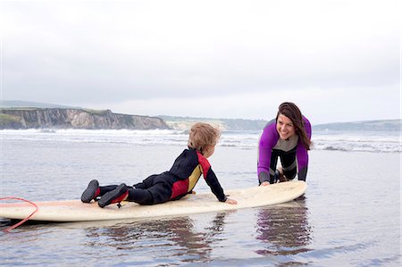 Mother teaching son how to surf Stock Photo - Premium Royalty-Free, Code: 649-07437744