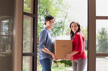 Young couple carrying cardboard box into new house Stock Photo - Premium Royalty-Free, Code: 649-07437887