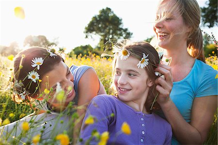 parent and teenager coloured people - Mother tying daisy chain around daughter's head Stock Photo - Premium Royalty-Free, Code: 649-07437900