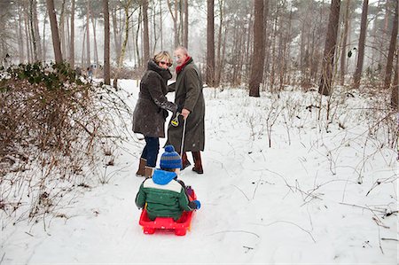 simsearch:649-07437959,k - Grandparents pulling grandson on toboggan in snow Foto de stock - Sin royalties Premium, Código: 649-07437956