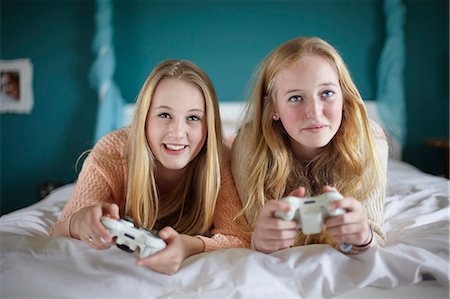 Two teenage girls playing on computer game in bedroom Stock Photo - Premium Royalty-Free, Code: 649-07520243