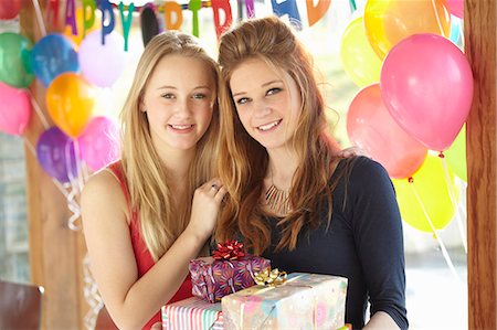 Two teenage girls sharing gifts at birthday party Stock Photo - Premium Royalty-Free, Code: 649-07520279
