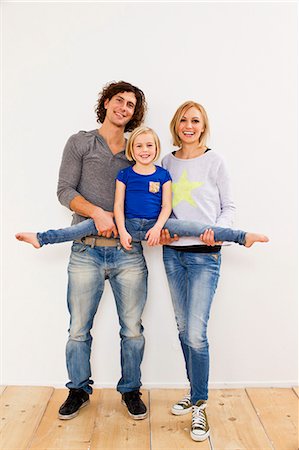 flexible - Studio portrait of couple holding up daughter Stock Photo - Premium Royalty-Free, Code: 649-07520644
