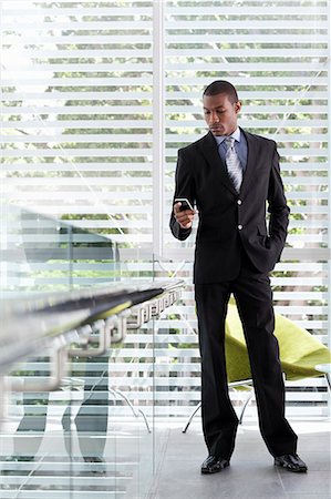 Businessman using texting on mobile phone in office Stock Photo - Premium Royalty-Free, Code: 649-07520810