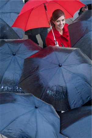rain in women - Young woman with red umbrella amongst black umbrella's Stock Photo - Premium Royalty-Free, Code: 649-07520862