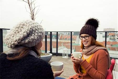 suéters - Two young adult women having coffee on rooftop terrace Foto de stock - Sin royalties Premium, Código: 649-07521034
