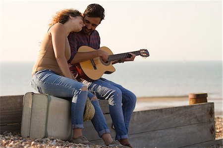 Young couple on beach, man playing guitar Stock Photo - Premium Royalty-Free, Code: 649-07521048