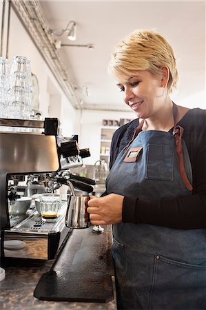 Barista heating up milk using coffee machine Stock Photo - Premium Royalty-Free, Code: 649-07559778