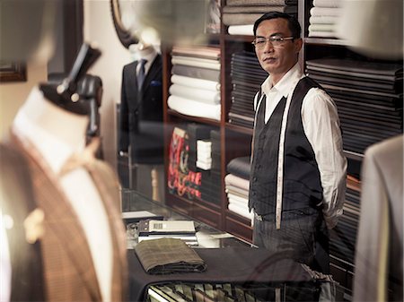 small business asian - Tailor standing behind counter in tailors shop Stock Photo - Premium Royalty-Free, Code: 649-07559862