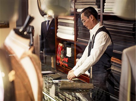 small business asian - Tailor working at counter in tailors shop Stock Photo - Premium Royalty-Free, Code: 649-07559863