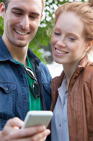 simsearch:649-07560129,k - Young couple looking at smartphone Foto de stock - Sin royalties Premium, Código: 649-07560138