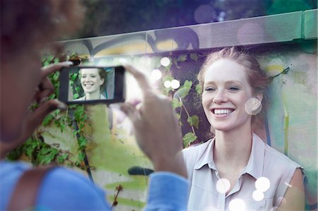 Two young women photographing using smartphone with lights coming out Stock Photo - Premium Royalty-Free, Code: 649-07560141