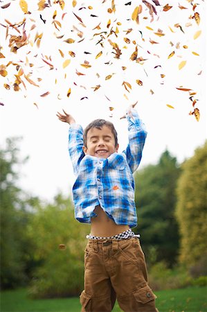 smiling boy - Male toddler in the garden throwing up autumn leaves Stock Photo - Premium Royalty-Free, Code: 649-07560359