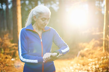 physically fit middle aged women - Mature woman wearing tracksuit top checking the time Stock Photo - Premium Royalty-Free, Code: 649-07560458