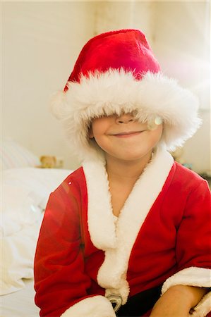 Portrait of young boy hidden by santa outfit cap Stock Photo - Premium Royalty-Free, Code: 649-07585487