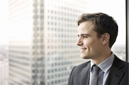 feliz - Portrait of young businessman looking out of office window Photographie de stock - Premium Libres de Droits, Code: 649-07596241